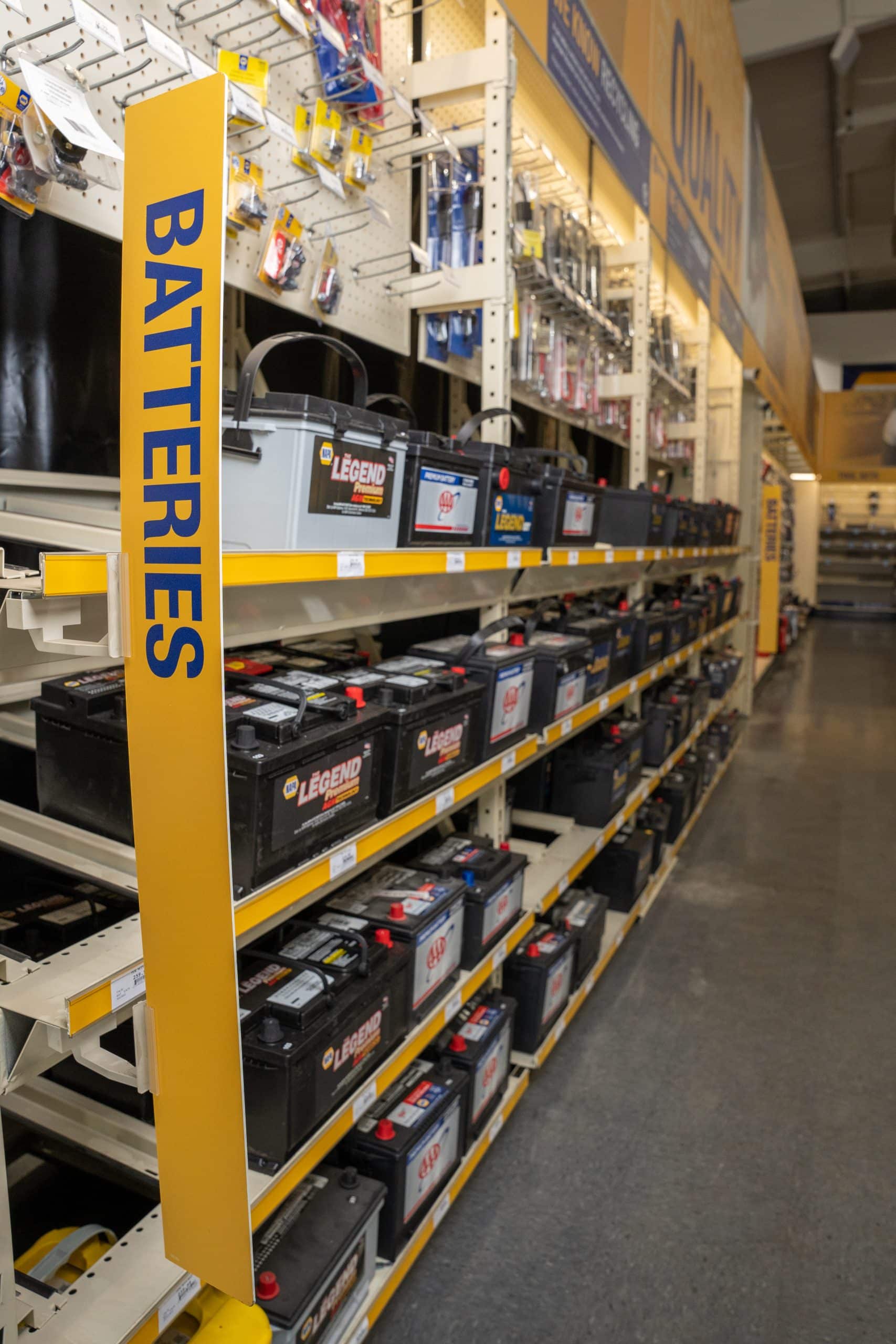 Battery aisle in NAPA Auto Parts Store with a shelf full of car batteries.